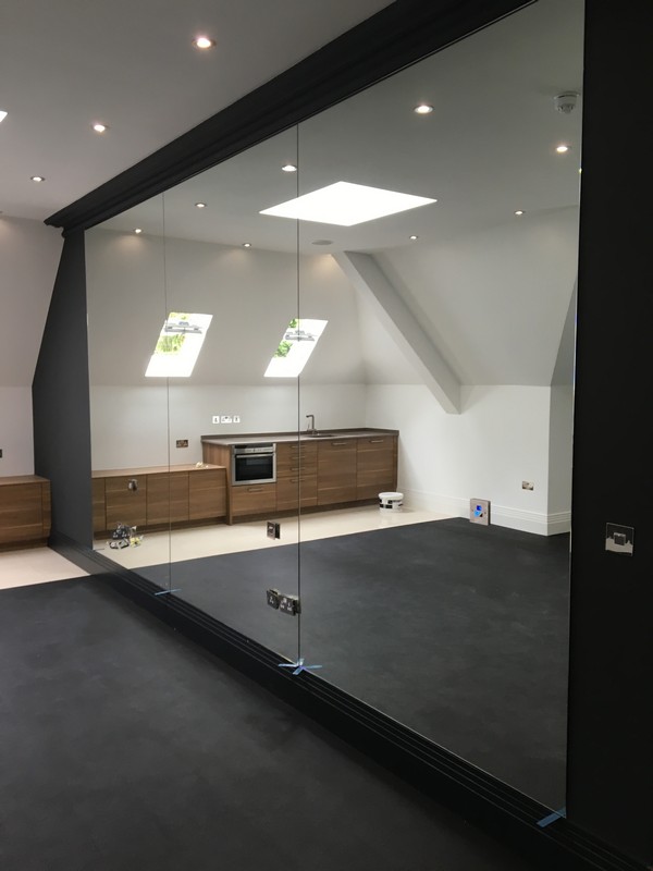 Frameless glass partition in loft conversion by Leyton glaziers