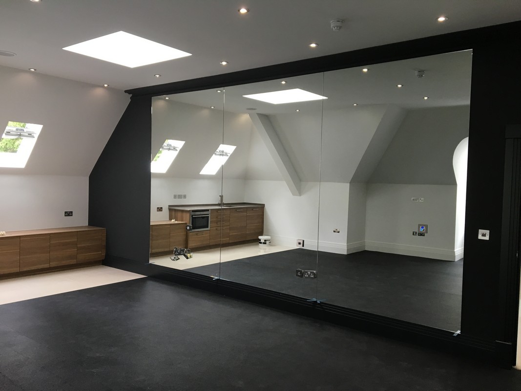 Frameless glass wall dividing loft conversion in Leyton
